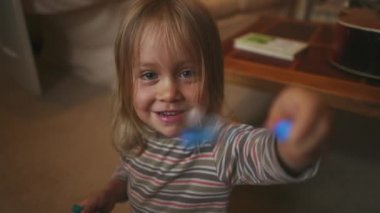 Küçük çocuk oynuyor, sabun köpükleri üflüyor.