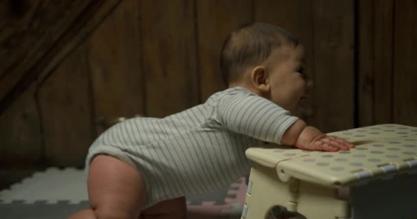かわいい赤ちゃんの男の子が椅子にもたれて立とうとして — ストック動画