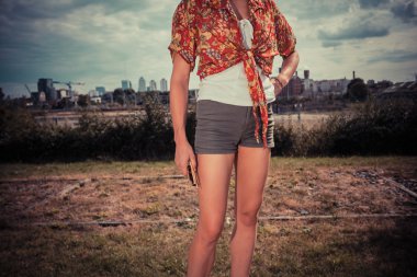 Genç bayan dışarıda duruyor.