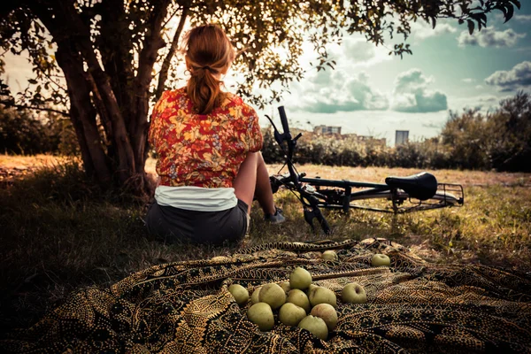 Giovane donna con mele e bicicletta — Foto Stock