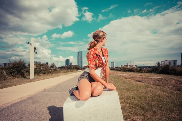 Mujer joven sentada afuera y mirando a la ciudad —  Fotos de Stock