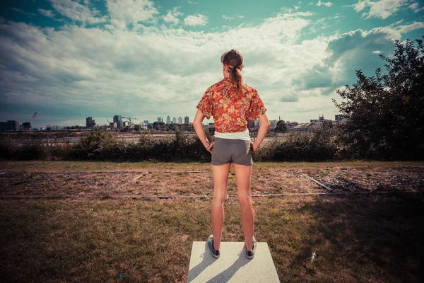 Młoda kobieta, stoją na dworze i patrząc na miasto — Zdjęcie stockowe