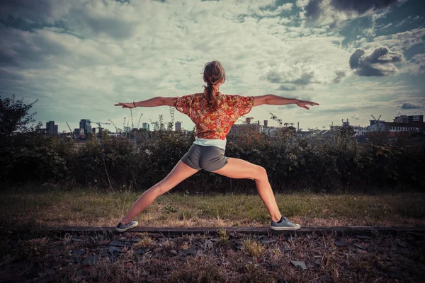 Young woman in a warrior pose outside — Stock Photo, Image