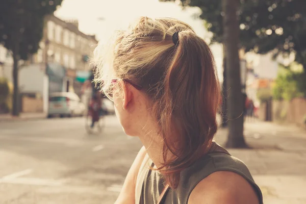 Jonge vrouw zitten in de straat — Stockfoto