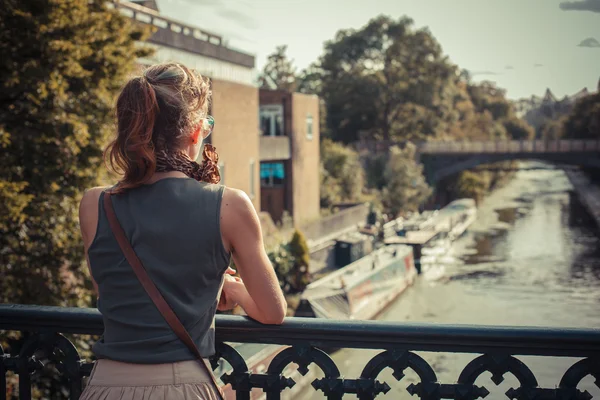 Young woman admiring the sunset from a bridge — Stock Photo, Image
