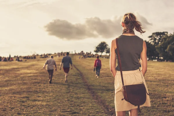 Jonge vrouw wandelen in het park bij zonsondergang — Stockfoto