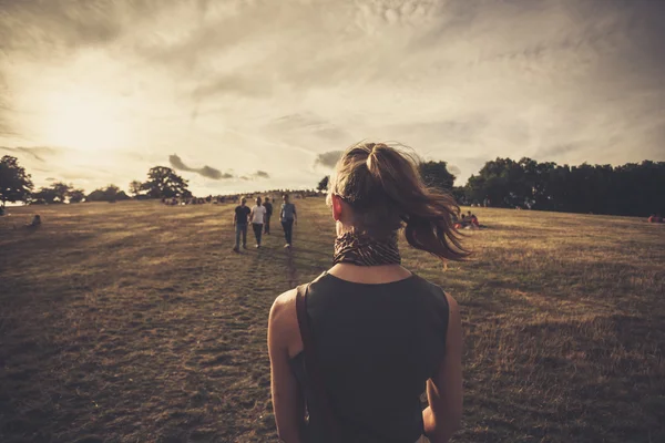 Jonge vrouw wandelen in het park bij zonsondergang — Stockfoto