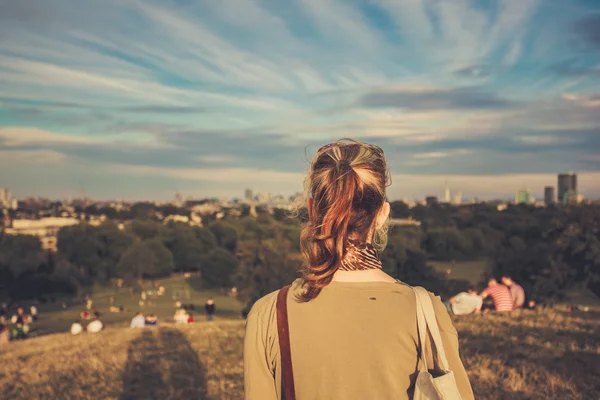 Jonge vrouw u geniet van uitzicht vanaf een heuvel — Stockfoto