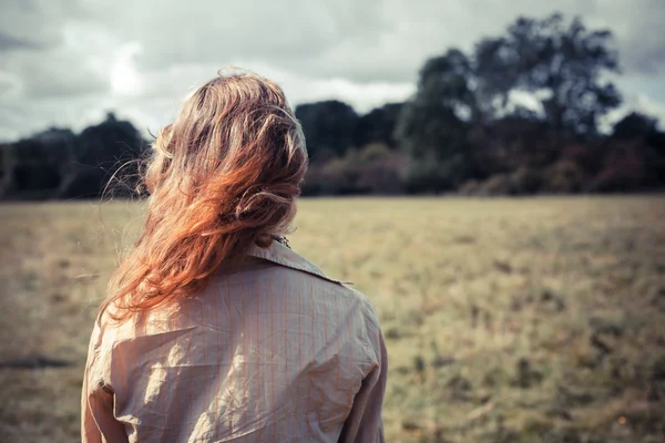 Jonge vrouw in een veld — Stockfoto