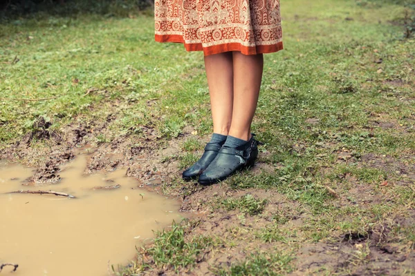 Jeune femme debout près d'une flaque d'eau dans la forêt — Photo