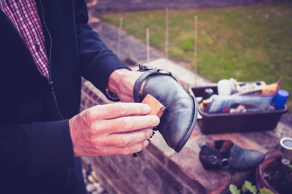 Senior man polishing shoes — Stock Photo, Image