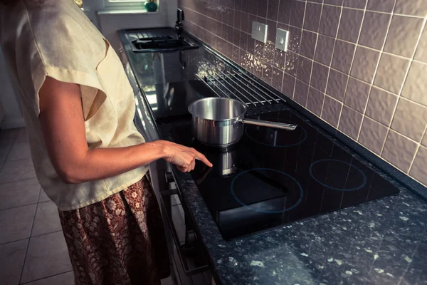 Jovem na cozinha cozinhar com panela — Fotografia de Stock