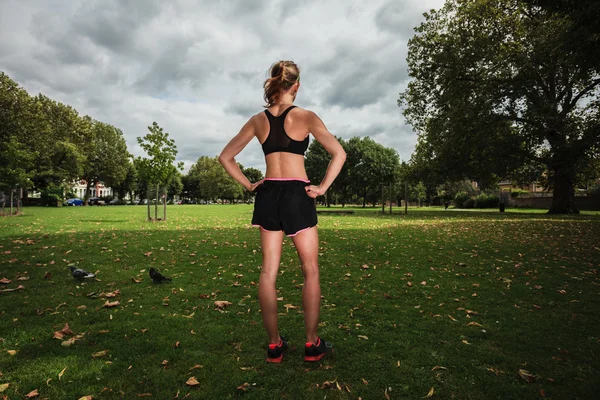 Jonge vrouw die zich uitstrekt en trainen in park — Stockfoto