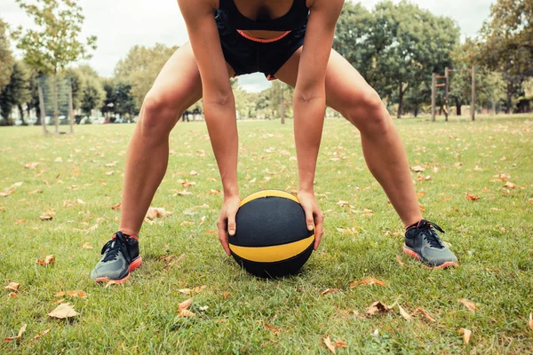 Young woman exercising with medicine ball in park — Stock Photo, Image