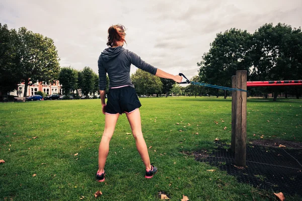 Donna che si allena con la fascia di resistenza nel parco — Foto Stock