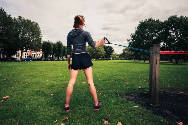 带阻力时在公园里锻炼的女人 — 图库照片