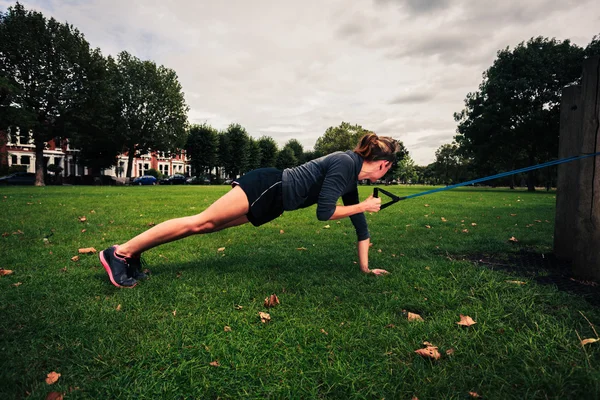 Woman working out with resistance band in the park — Stock Photo, Image