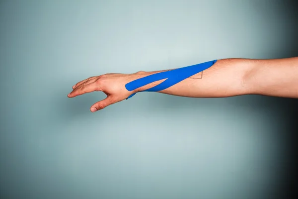 Arm met kinesio tape — Stockfoto