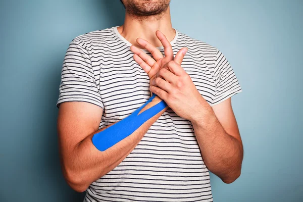 Young man with kinesio tape on his arm — Stock Photo, Image