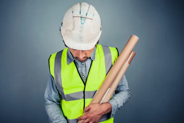 Young engineer with building plans — Stock Photo, Image