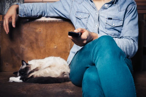 Jovem com gato assistindo tv — Fotografia de Stock