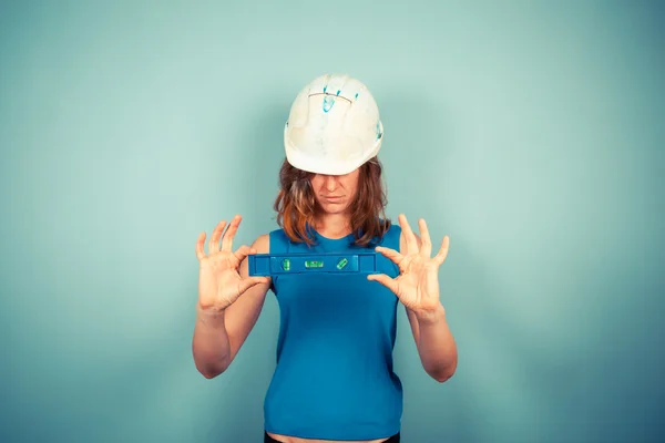 Young female buidler holding a level — Stock Photo, Image