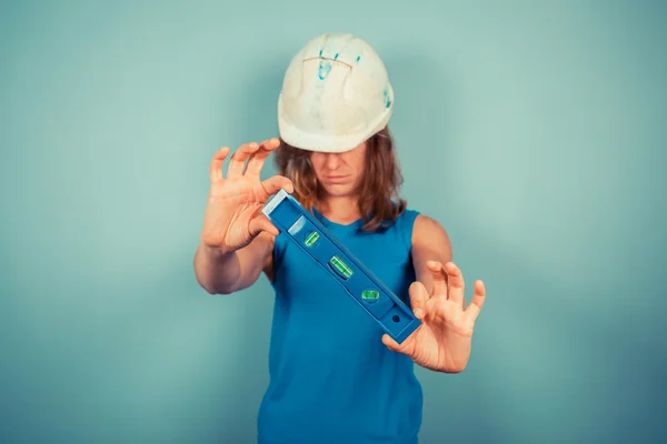 Young female buidler holding a level — Stock Photo, Image