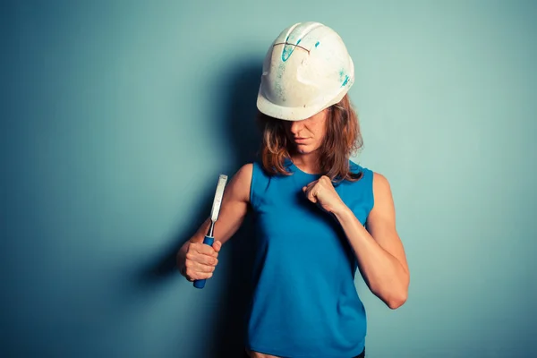 Joven constructora sosteniendo un cincel agresivamente — Foto de Stock