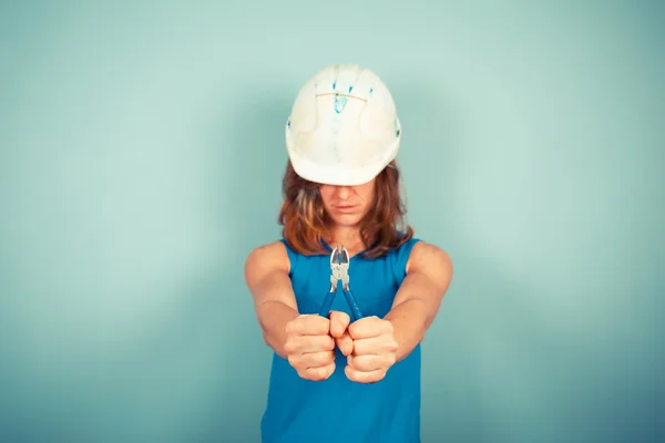 Joven constructora sosteniendo alicates — Foto de Stock