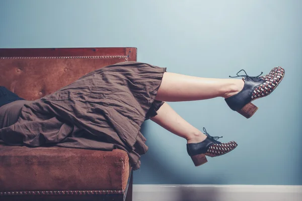 Молода жінка розслабляється на дивані — стокове фото
