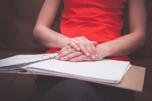 Woman sitting on sofa with documents — Stock Photo, Image