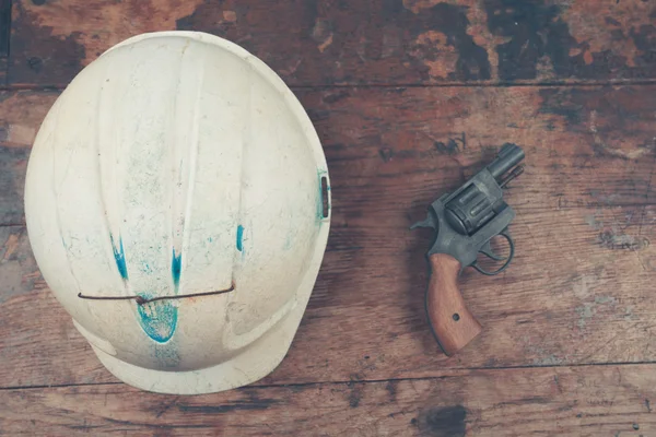 Safety helmet and revolver — Stock Photo, Image