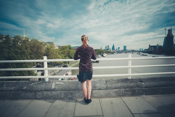 Young woman standing on bridge in city — Stock Photo, Image