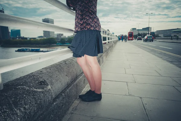 Young woman standing on bridge in city — Stock Photo, Image