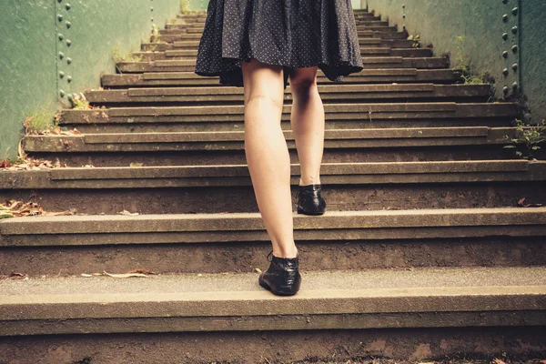 Young woman walking up stairs — Stock Photo, Image