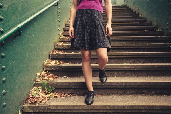 Jovem mulher descendo escadas — Fotografia de Stock