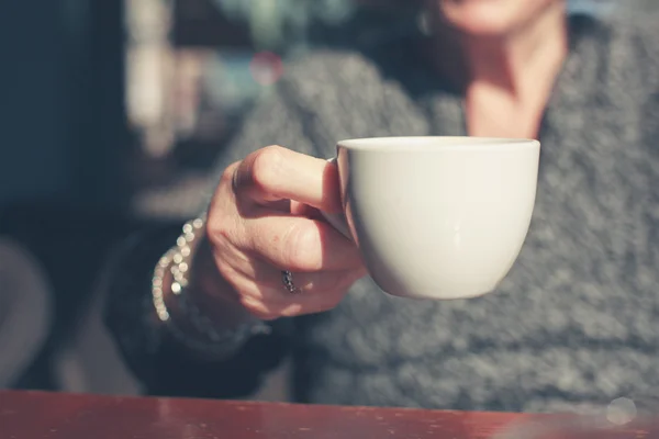 Äldre kvinna dricker kaffe utanför — Stockfoto