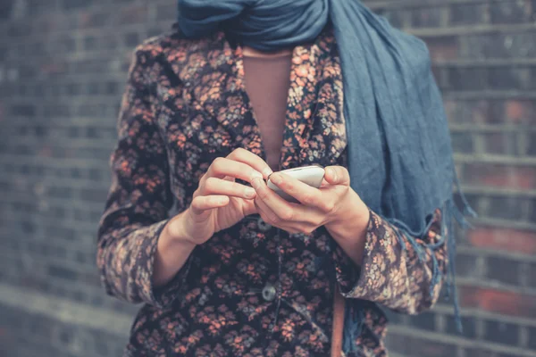 Jeune femme avec téléphone intelligent dans la rue — Photo