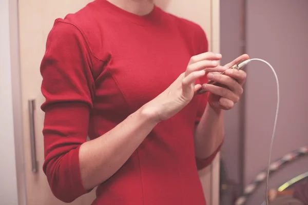 Mulher carregando seu telefone — Fotografia de Stock