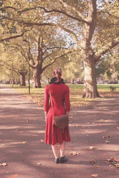 Ung kvinna promenader i parken — Stockfoto