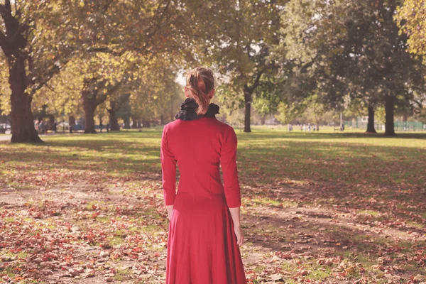 Ung kvinna promenader i parken — Stockfoto