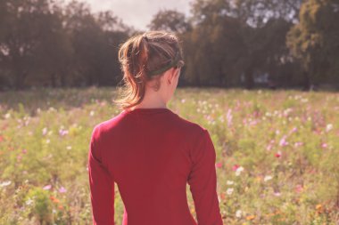 Gün batımında çayırda genç kadın