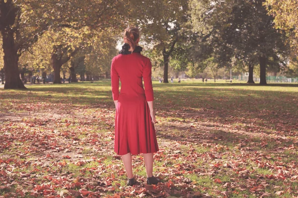 Ung kvinna promenader i parken — Stockfoto