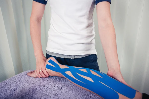 Physiotherapist applying kinesio tape — Stock Photo, Image