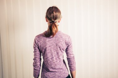 Perdeleri tarafından duran genç kadın