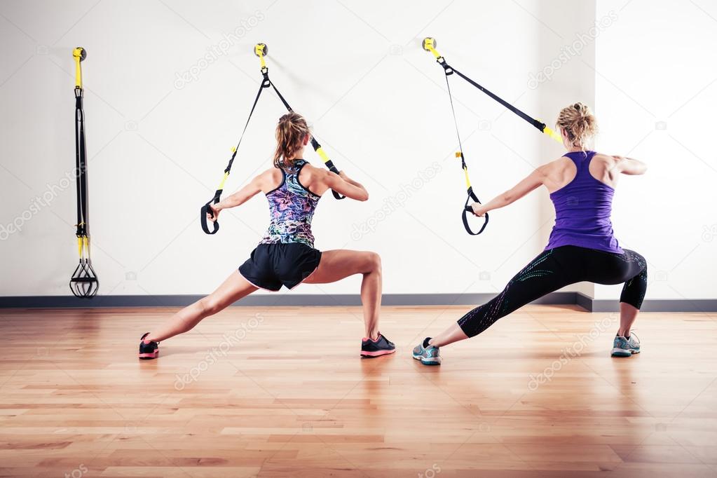 Two women working out with straps