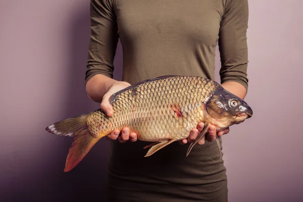 Young woman holding a carp — Stock Photo, Image