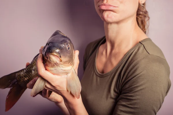 傻的年轻女人，与鲤鱼合影 — 图库照片