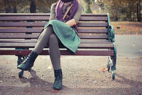 Jeune femme assise sur un banc de parc — Photo