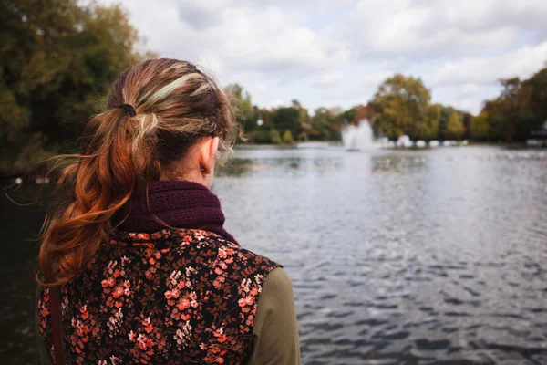 Женщина смотрит на озеро в парке — стоковое фото